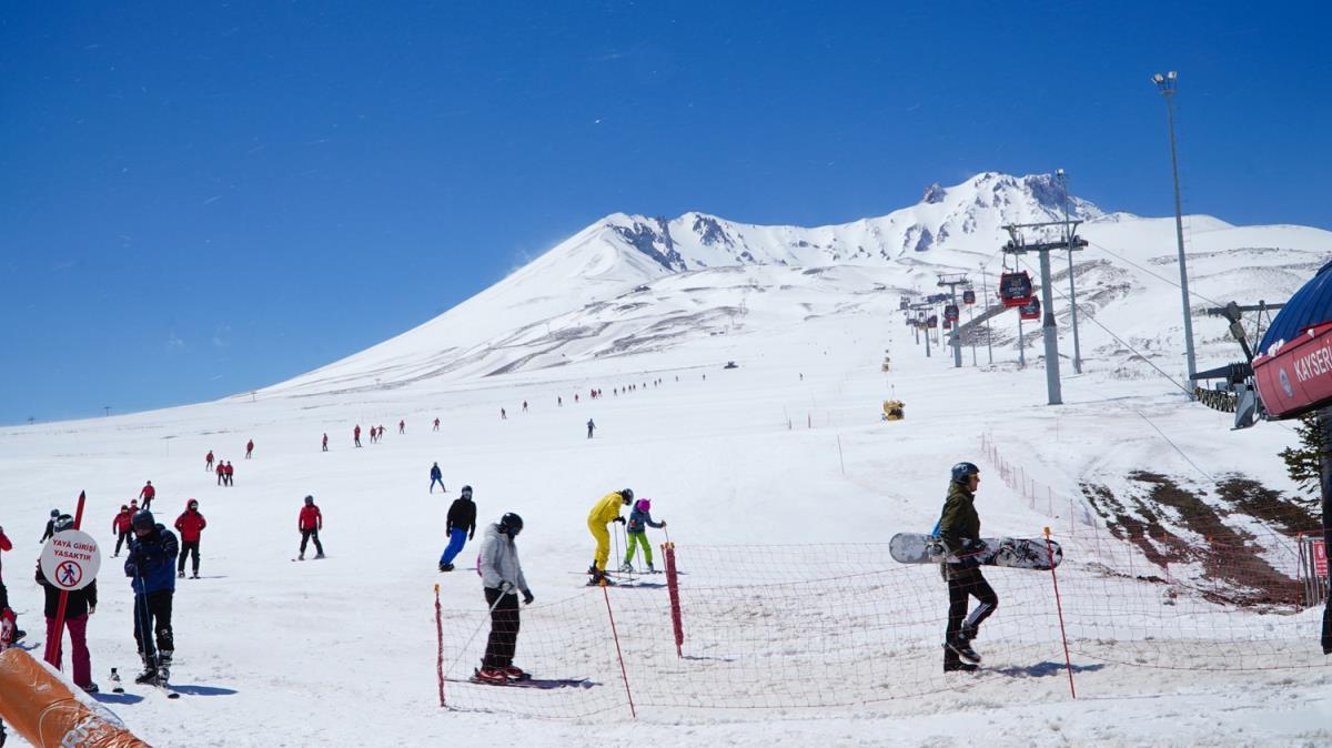 Erciyes'teki kayak merkezinde ziyaretiler, ilkbaharda kayak yapma imkan buluyor